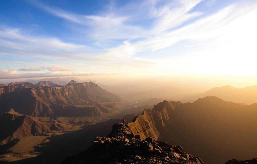 Vue panoramique spectaculaire sur les remparts du Cirque de Cilaos au coucher du soleil avec un observateur sur un promontoire